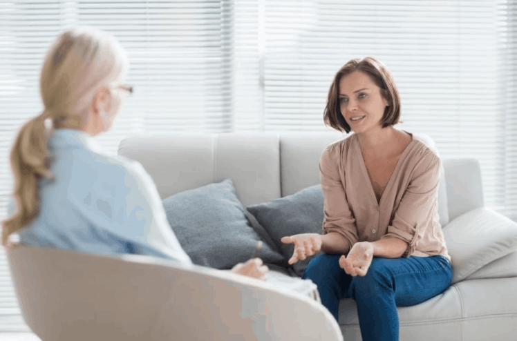 Woman engaging in individual therapy session with psychologist, discussing mental health and personal challenges in a comfortable setting.